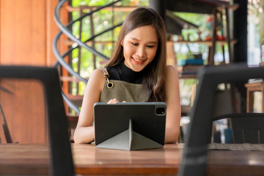 Seorang wanita sedang menggunakan tablet untuk pelajaran jarak jauh