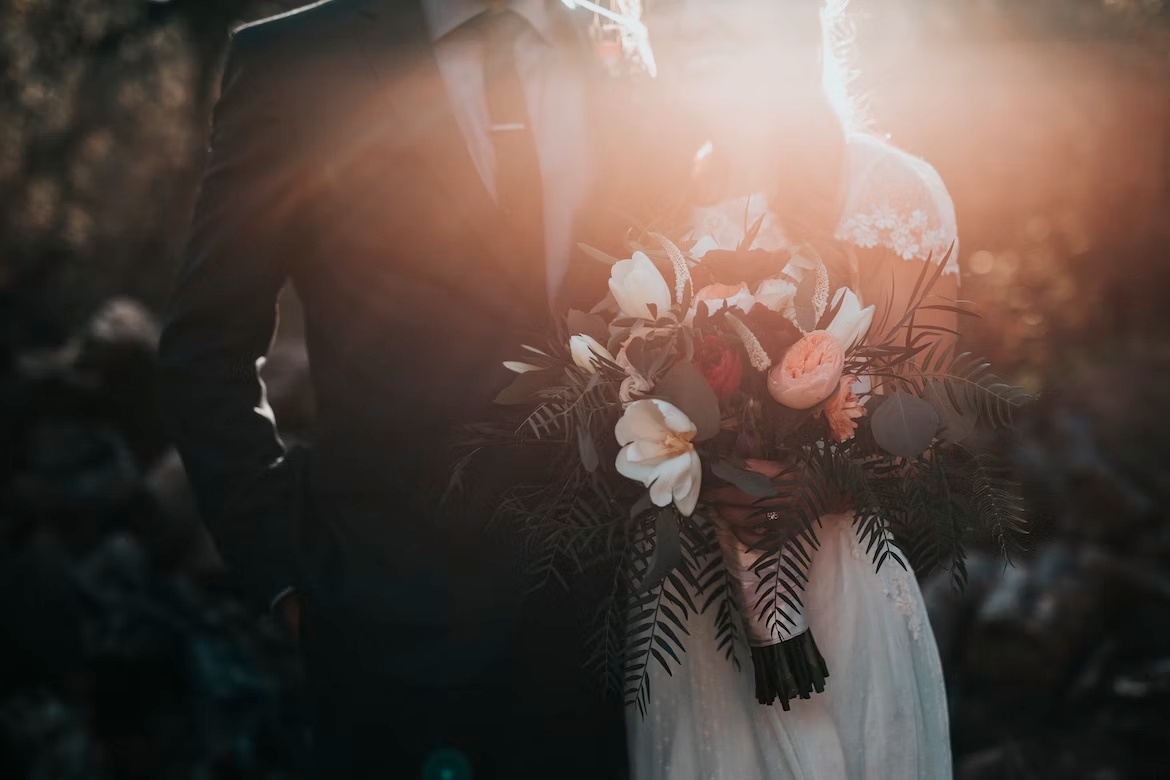 Man and woman are marrying with flowers in woman's hand