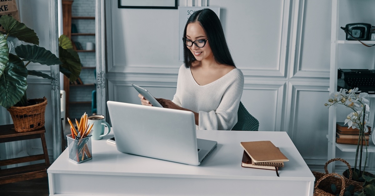 woman in glasses working at a desk