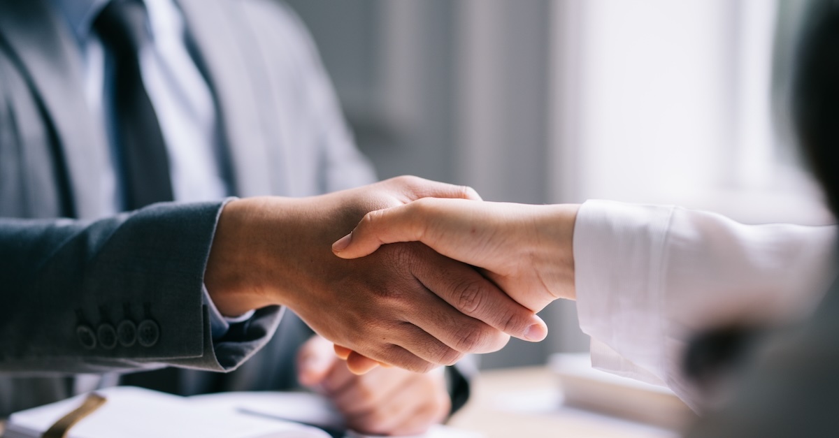 two people engage in a business handshake