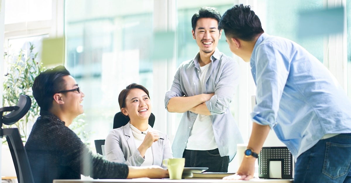 group of four people smiling and having fun at work