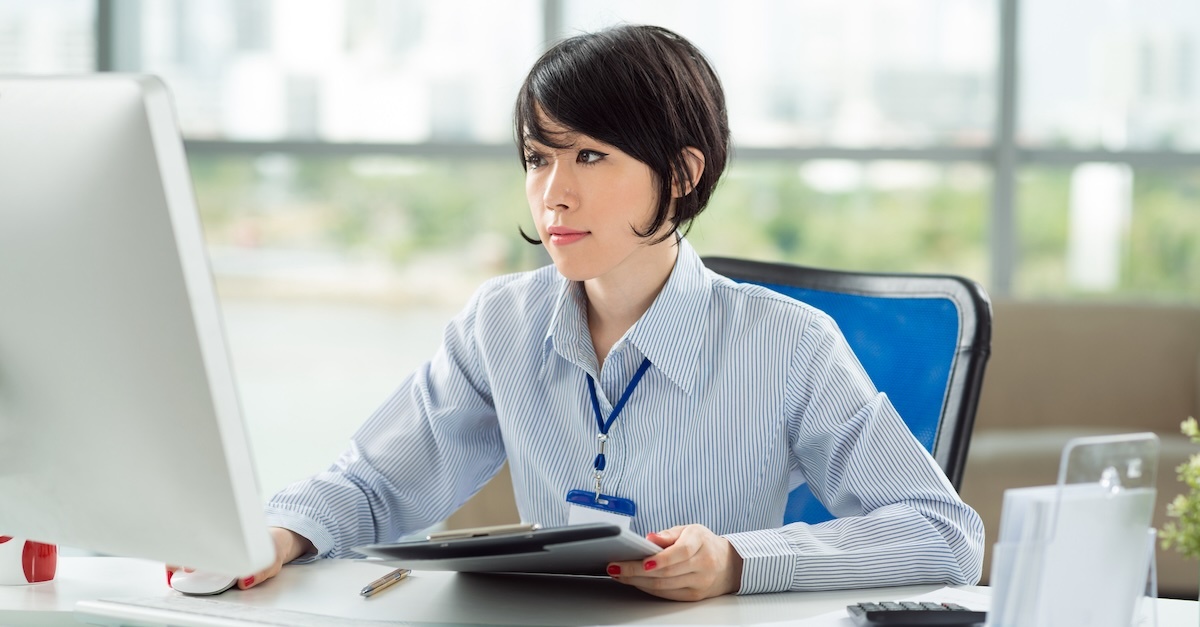 Sales woman working at desk on sales goals to hit commission numbers