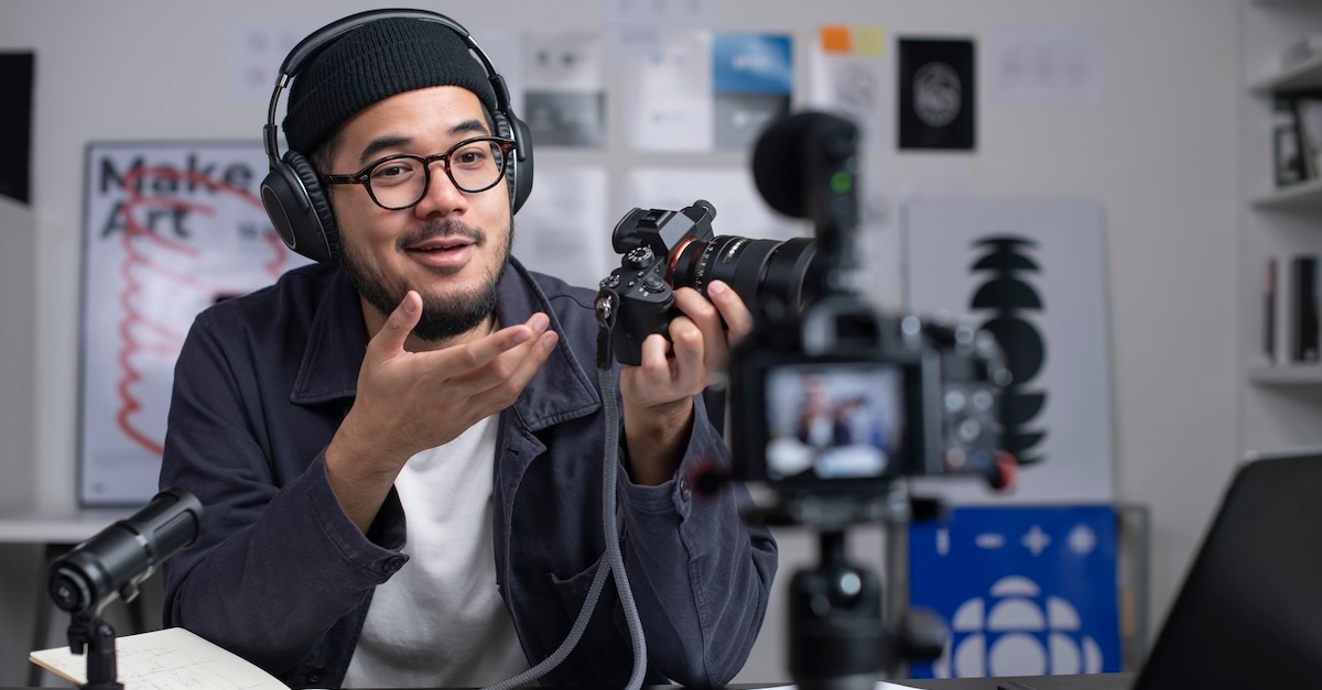 man with camera wearing headphones in a studio