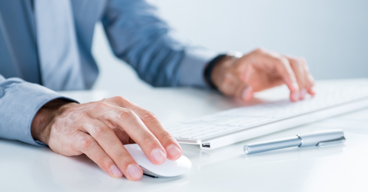 Man in a business attire typing on a keyboard