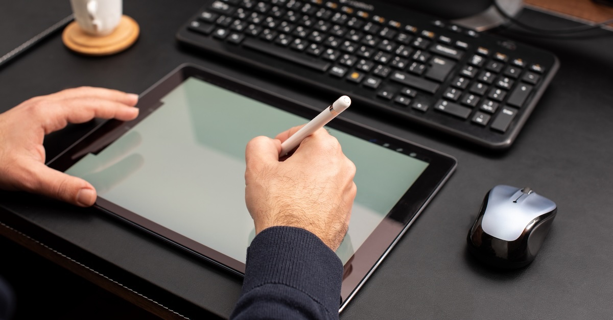 man writing on tablet