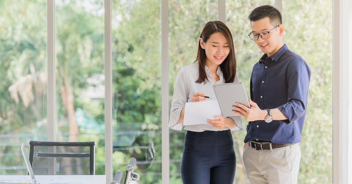 Two people in discussion while using a tab