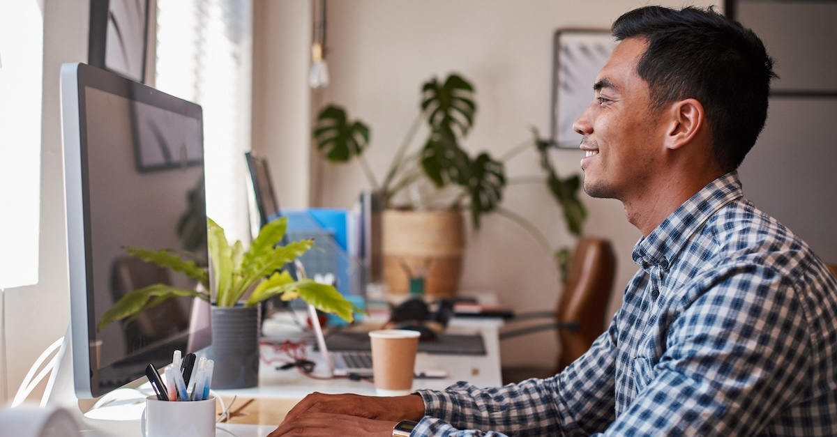 man looking at computer plaid shirt