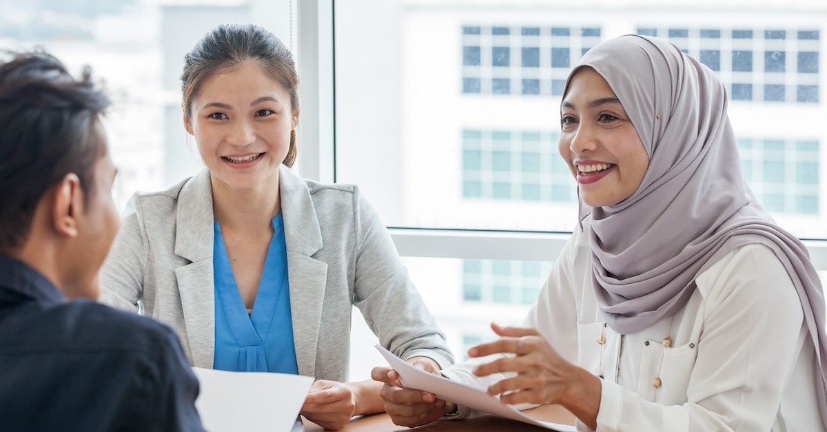 Group of three people in discussion reviewing a potential job offer