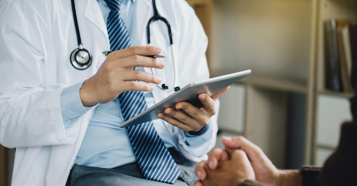 a healthcare professional speaks with a patient in a clinical setting