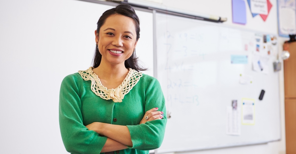 Woman teacher in a green sweater in a classroom