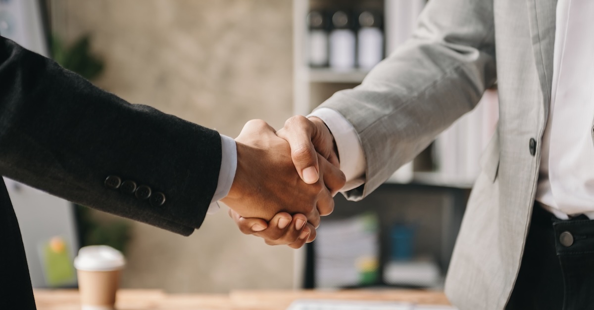 Two men in suits in a handshake