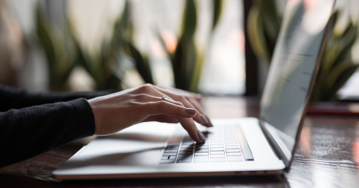 A woman typing on her laptop