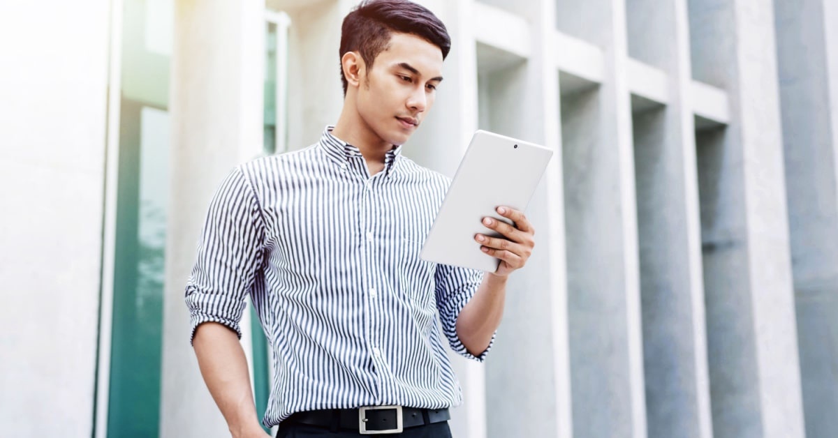 A man holding  tablet while wearing business casual tops 