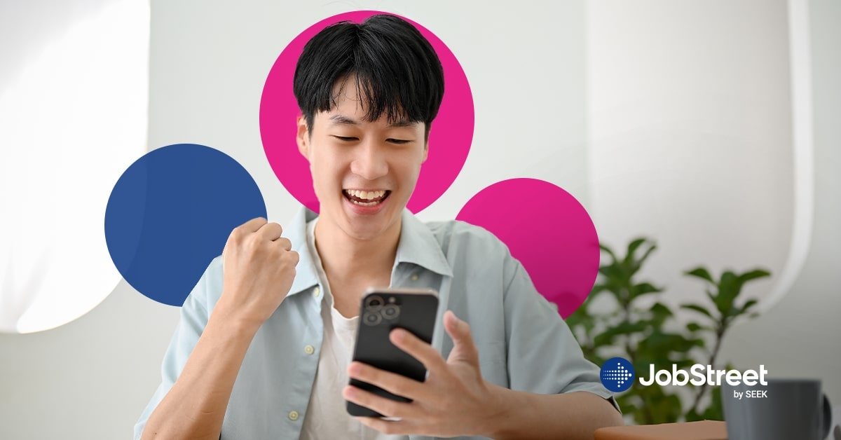 A man happily looking at his phone while wearing a business casual clothes for men