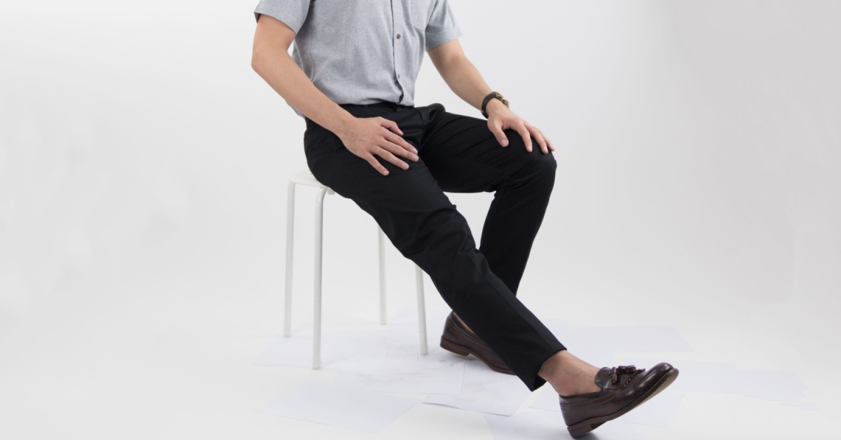 A man sitting in a chair while wearing a business casual bottoms for men