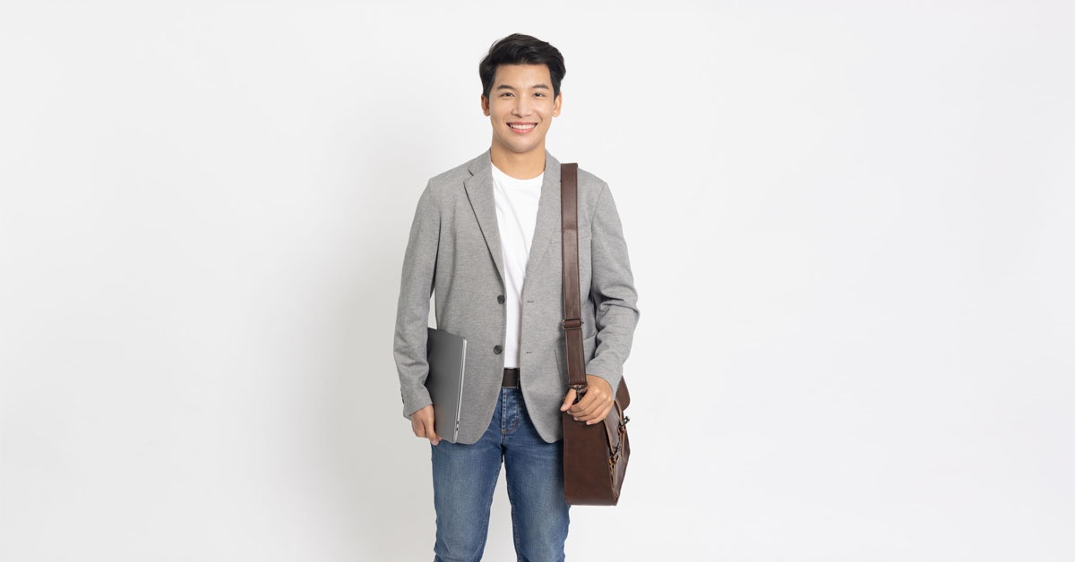 A man wearing a business casual attire, holding a laptop