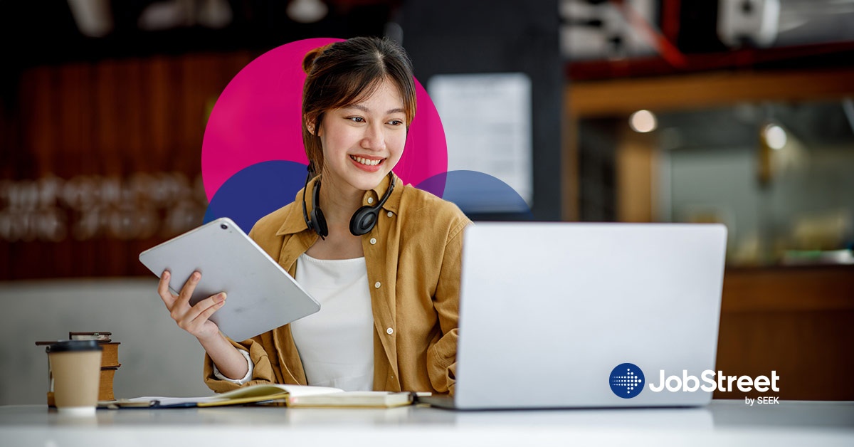 A female working using smart goals in the laptop while holding a tablet