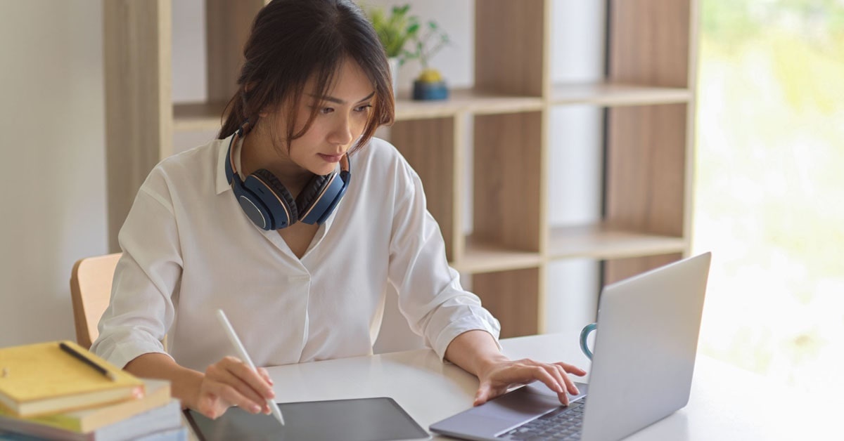 A female freelancer working in front of a laptop and tablet