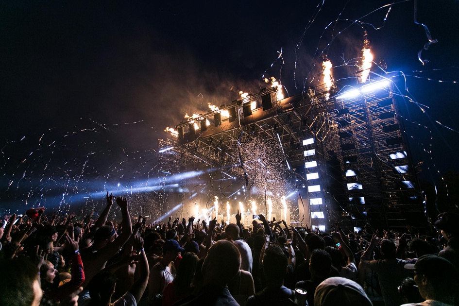 crowd cheering and enjoying a performance at a concert