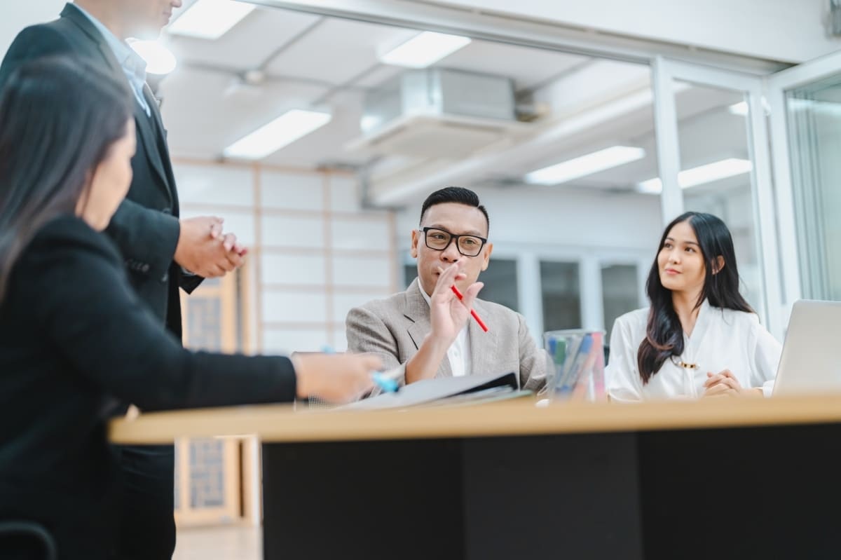 Seorang pimpinan divisi sedang melakukan evaluasi teamwork di tempat kerja. (Sumber: Envato)