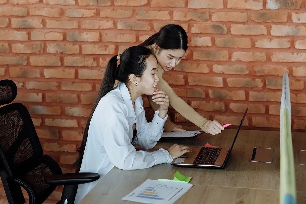 Dua orang karyawan yang visioner sedang berdiskusi di kantor.