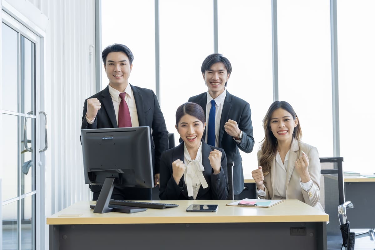 Empat orang karyawan tampak bahagia setelah mengetahui jobdesk masing-masing. (Sumber : Envato)