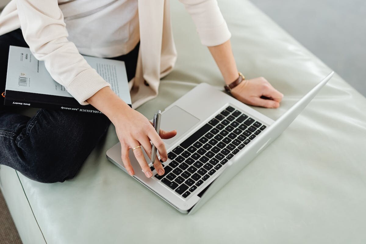 Seorang karyawan wanita sedang mengakses Google Data Studio atau Google Looker Studio di laptop.