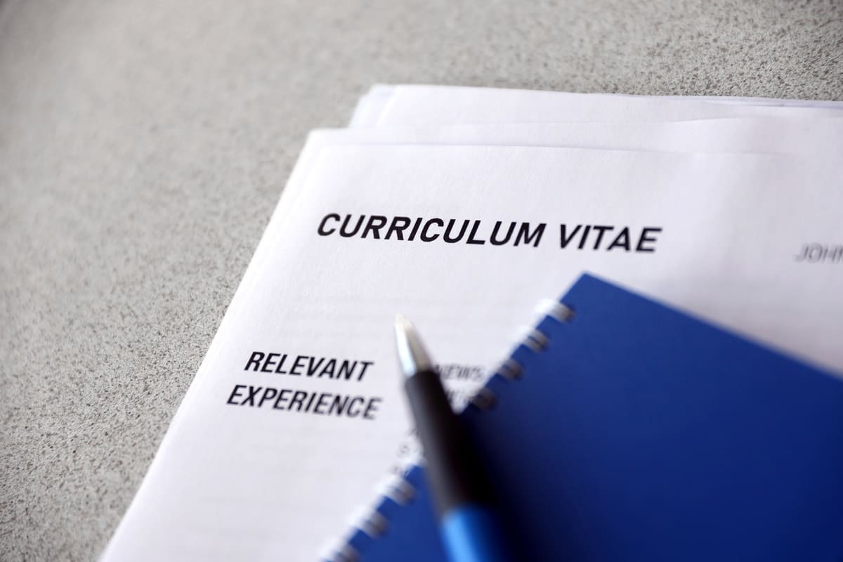 Ilustrasi dokumen Curriculum Vitae (CV) atau daftar riwayat hidup di meja HRD kantor.