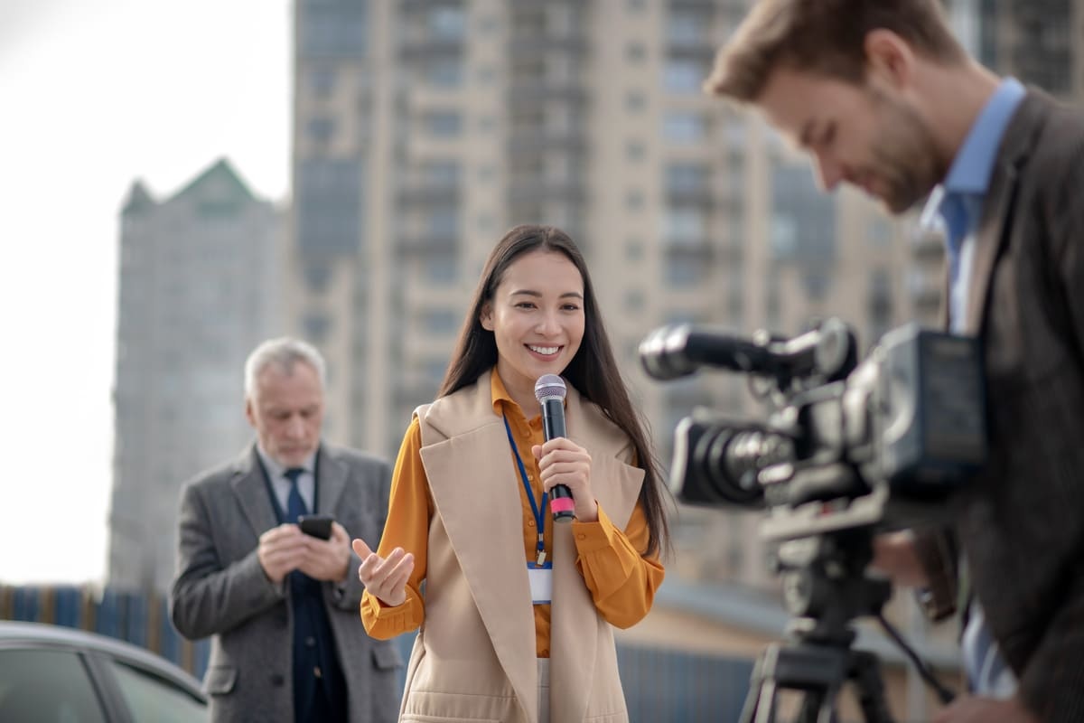 Seorang wanita tampak bahagia ketika bekerja di dunia broadcasting sebagai reporter berita.