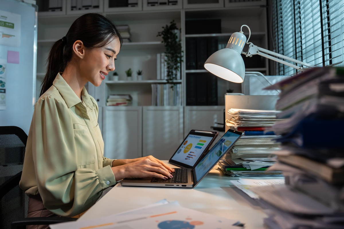 Seorang karyawan wanita sedang bekerja menggunakan aplikasi Microsoft Word.