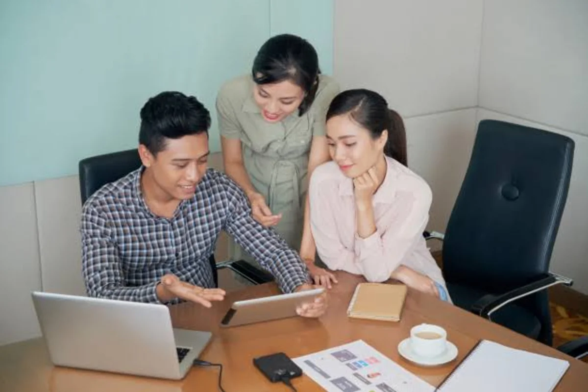 Tiga orang karyawan sedang berdiskusi soal perbedaan kompetensi dan keterampilan.