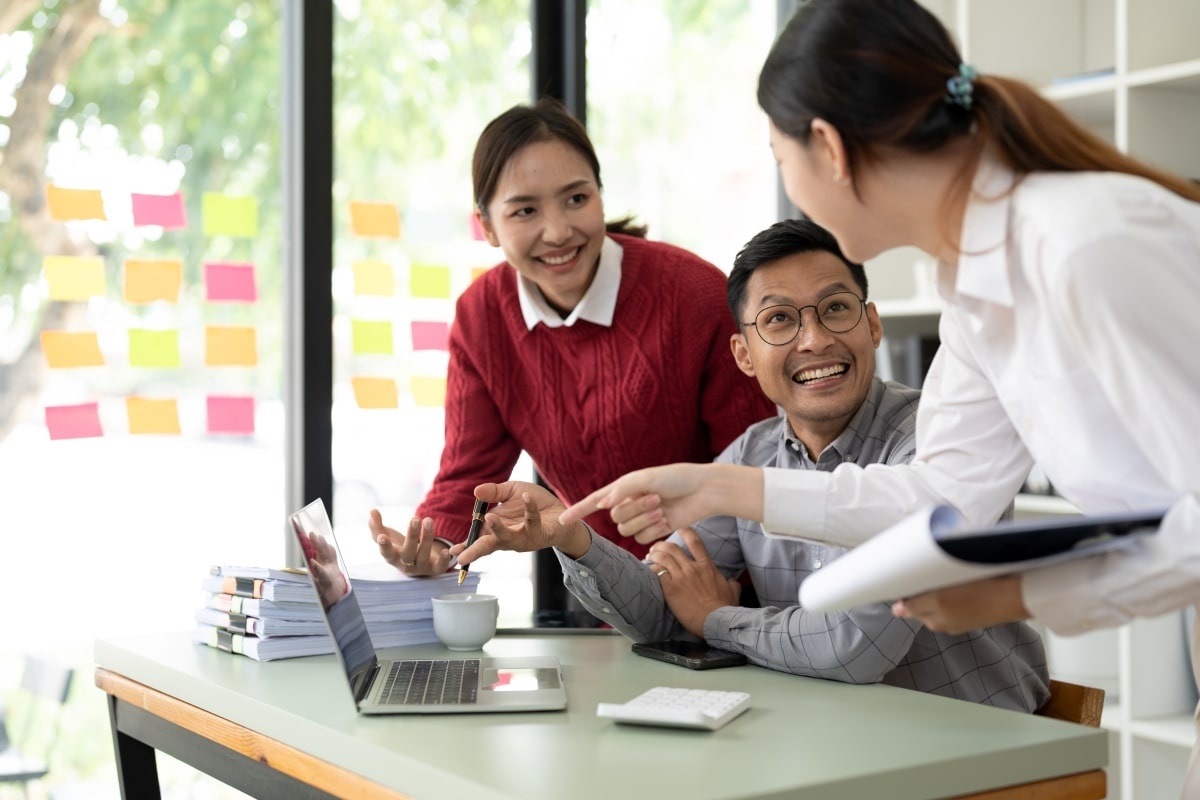 Tiga orang karyawan sedang berdiskusi soal life skill. (Sumber: Envato)