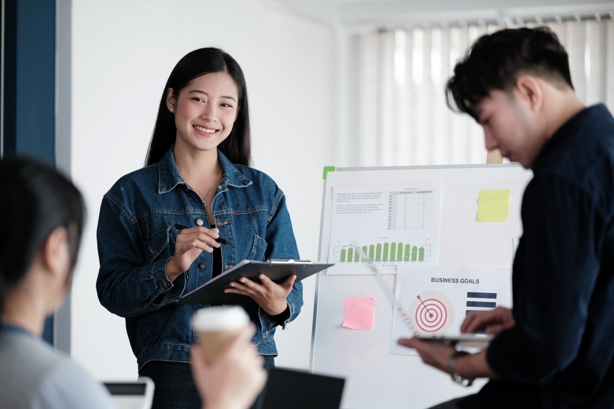 Seorang karyawan wanita yang punya pola pikir growth mindset tampak percaya diri ketika melakukan presentasi di depan klien. (Sumber: Envato)