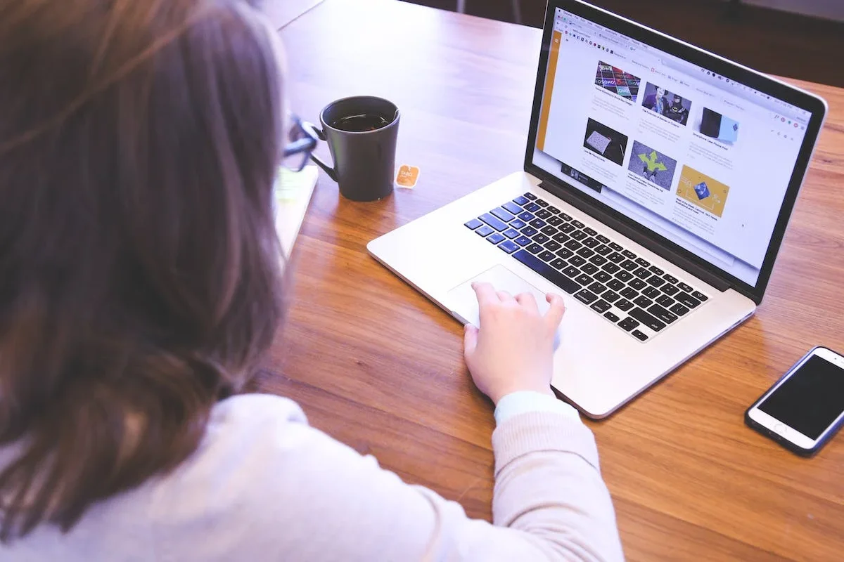 Seorang karyawan wanita sedang mengakses Google Data Studio atau Google Looker Studio di laptop.