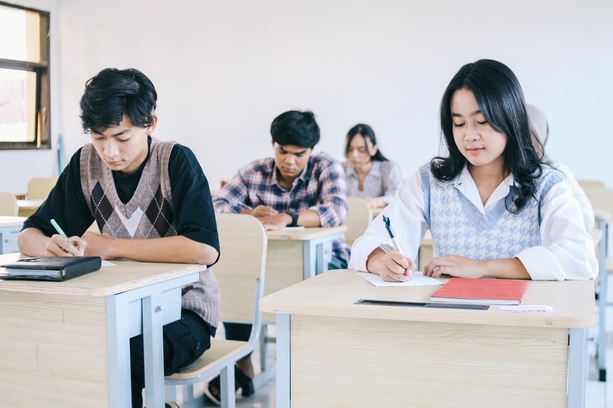 Dua orang calon karyawan yang mengikuti proses rekrutmen kerja sedang mengerjakan soal TPA. (Sumber : Envato)