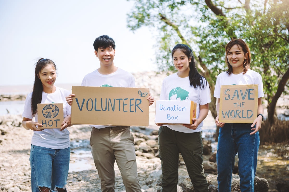 Empat orang volunteer kegiatan bersih-bersih pantai dan penggalangan dana donasi bencana alam.