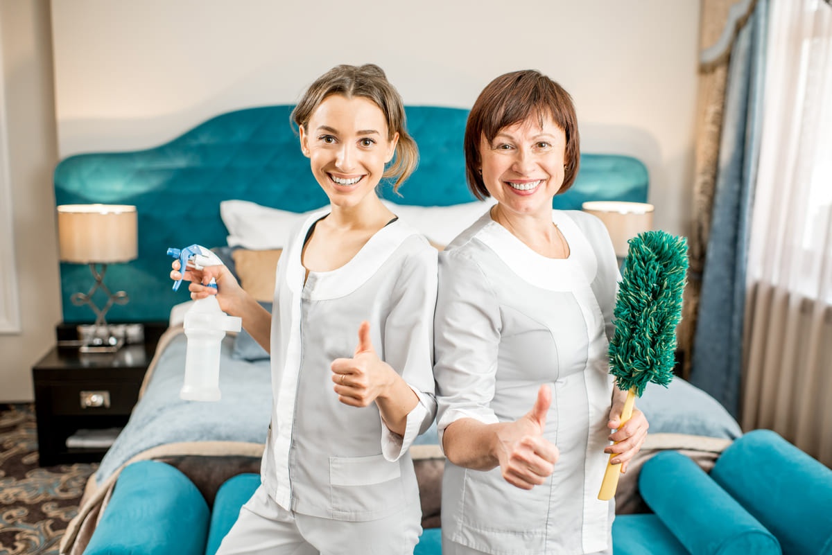 Dua orang housekeeper wanita tampak bahagia saat bekerja.