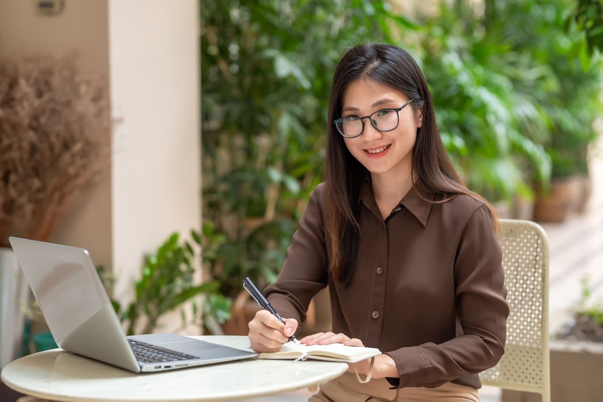 Seorang wanita sedang menulis surat lamaran kerja untuk pabrik. (Sumber: Envato)