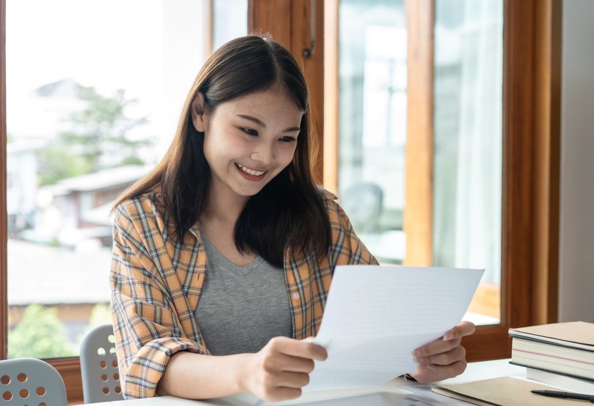 Seorang karyawan wanita sedang membuat motivation letter beasiswa untuk melanjutkan studi. (Sumber: Envato)