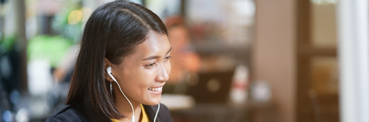 Asian woman with headphones smiling