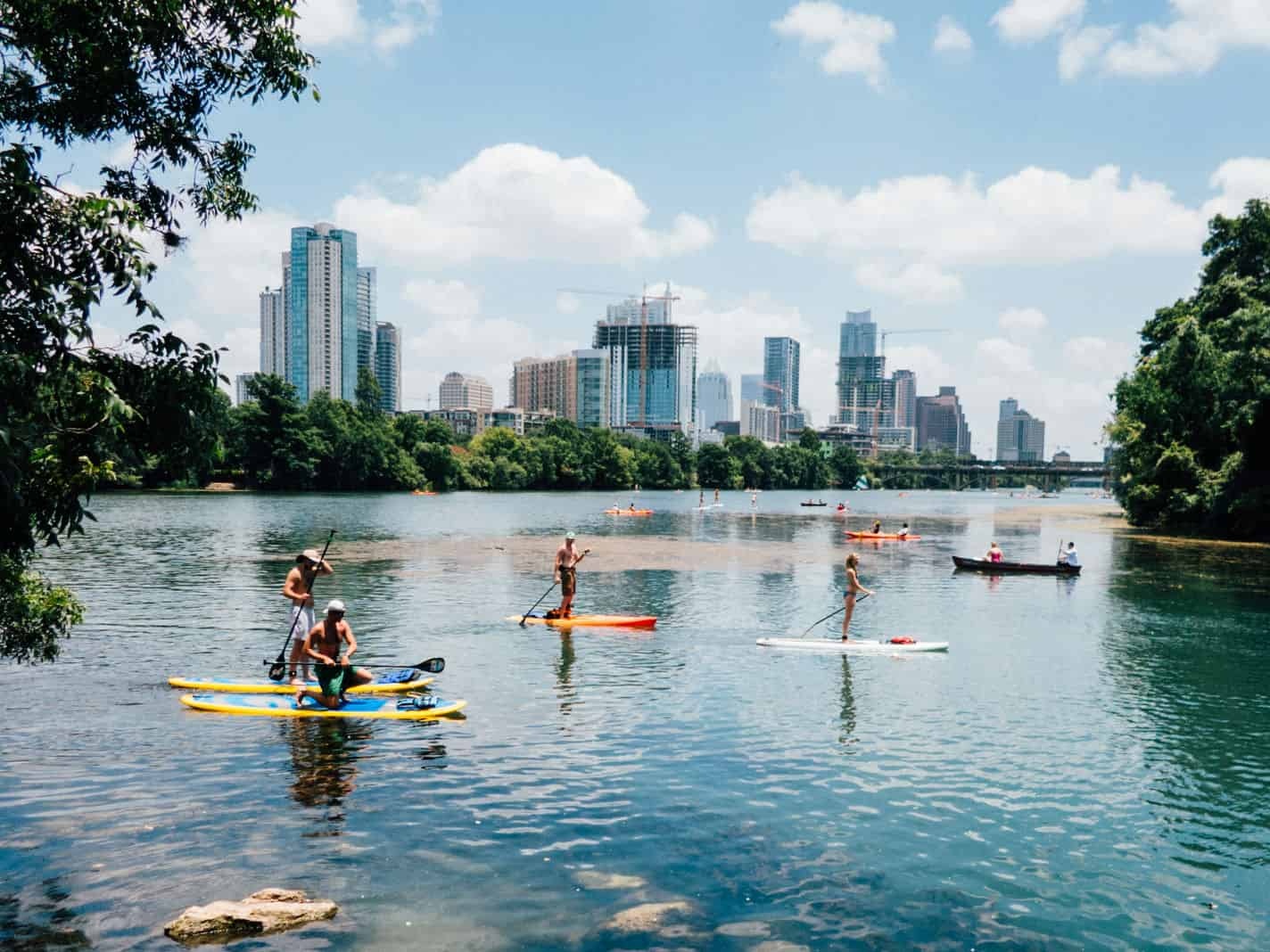 Austin residents paddle-boarding on the Travis River