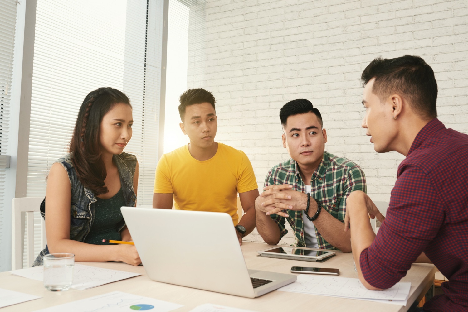 Tiga orang pekerja muda sedang menerapkan empathetic listening terhadap satu rekan kerja lelakinya. (Image by pressfoto on Freepik) 