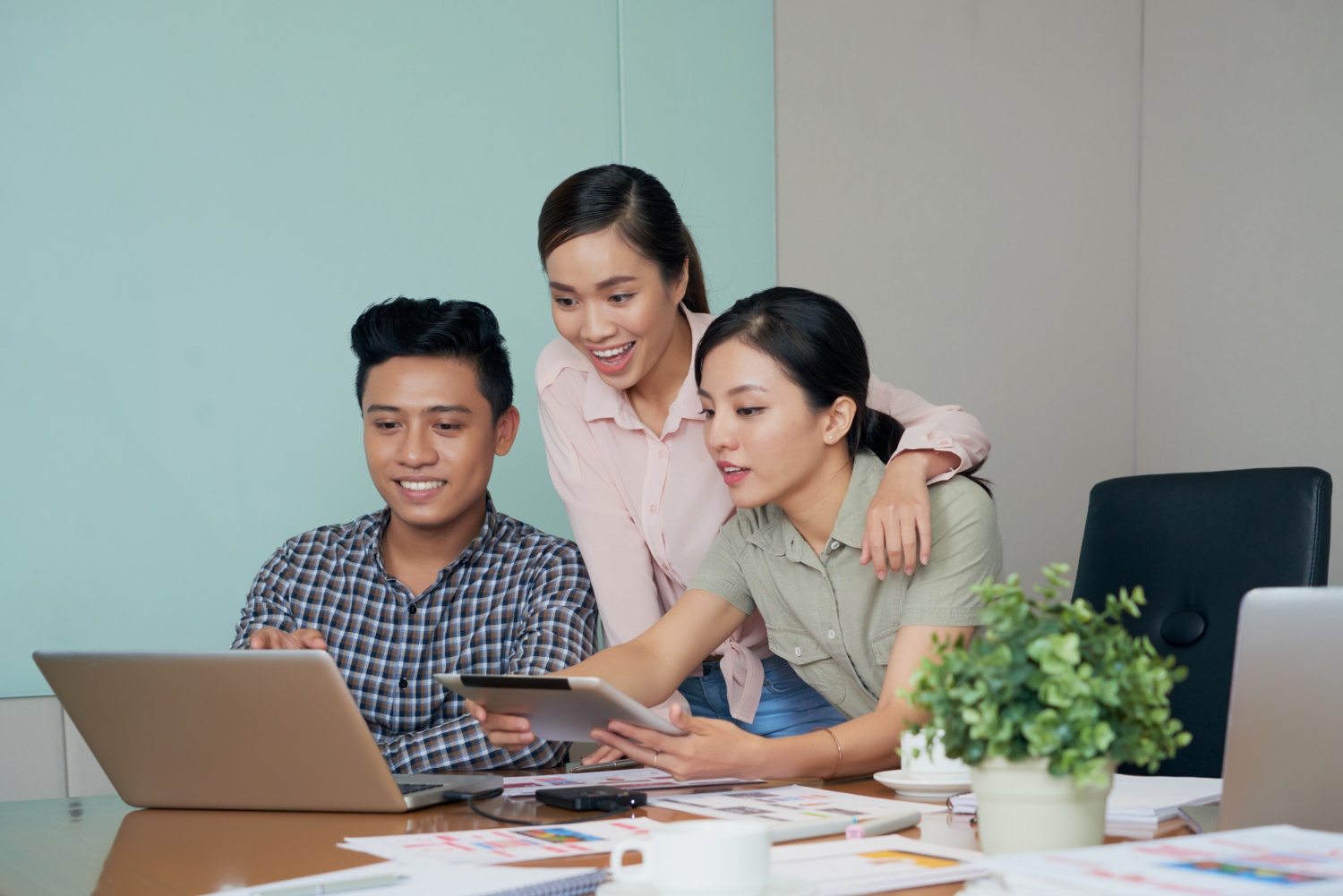 Tiga orang karyawan yang berstatus PKWT sedang bercengkrama di kantor.