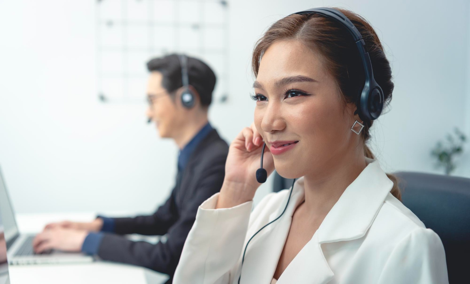 Customer service wanita sedang tersenyum melayani pelanggan menggunakan headphone. (Image by DC Studio on Freepik) 