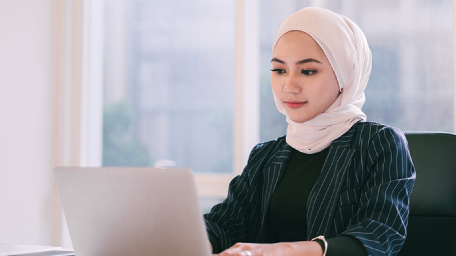 Woman writing on laptop