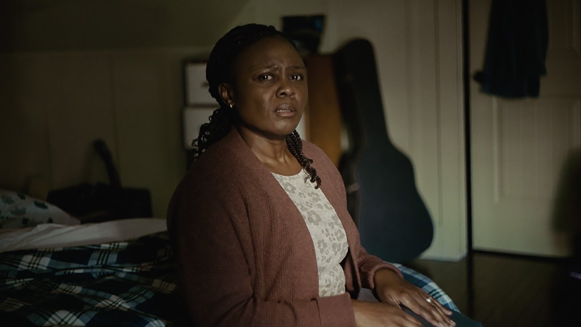 person looking at camera sitting on bed