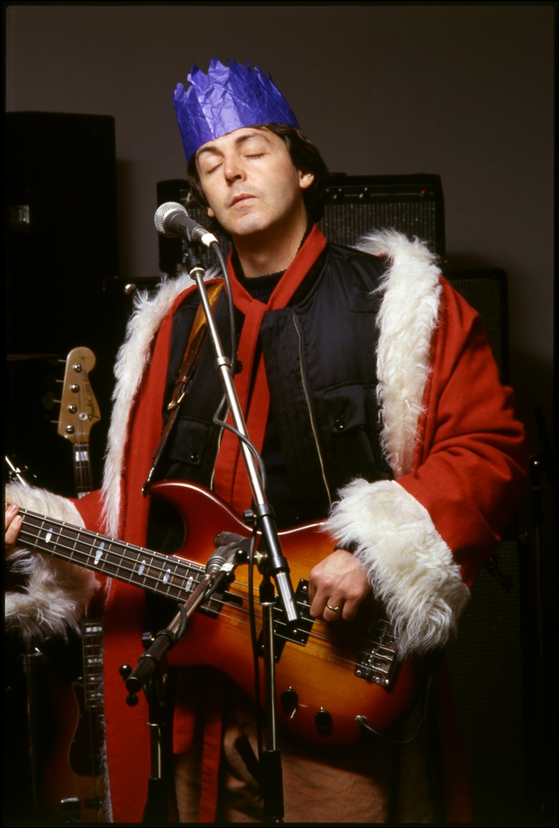 Photo of Paul performing in a Christmas hat and Santa coat.
