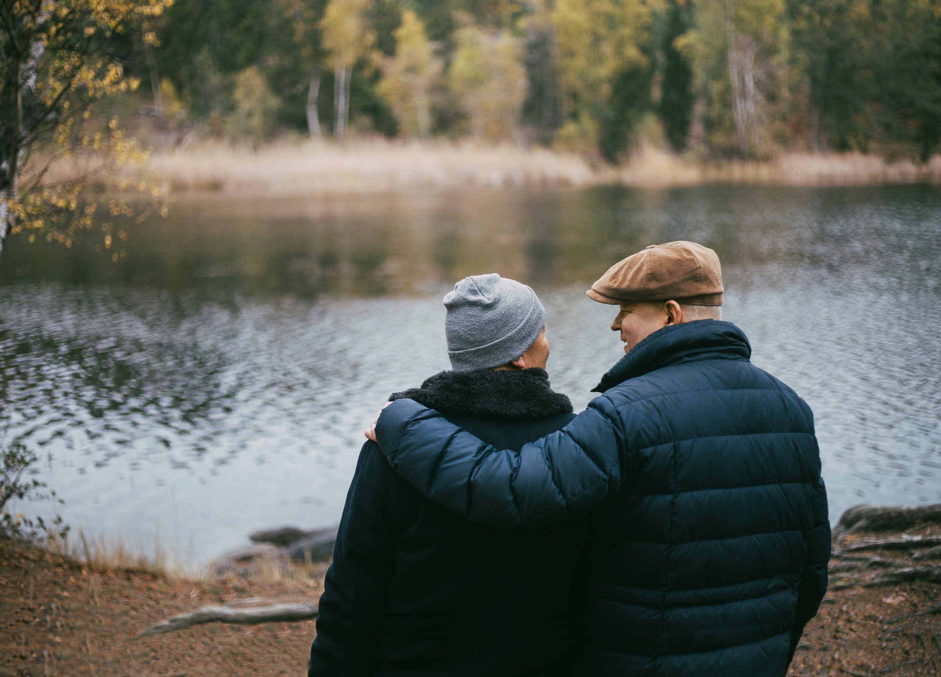 Elderly couple hugging in front of river