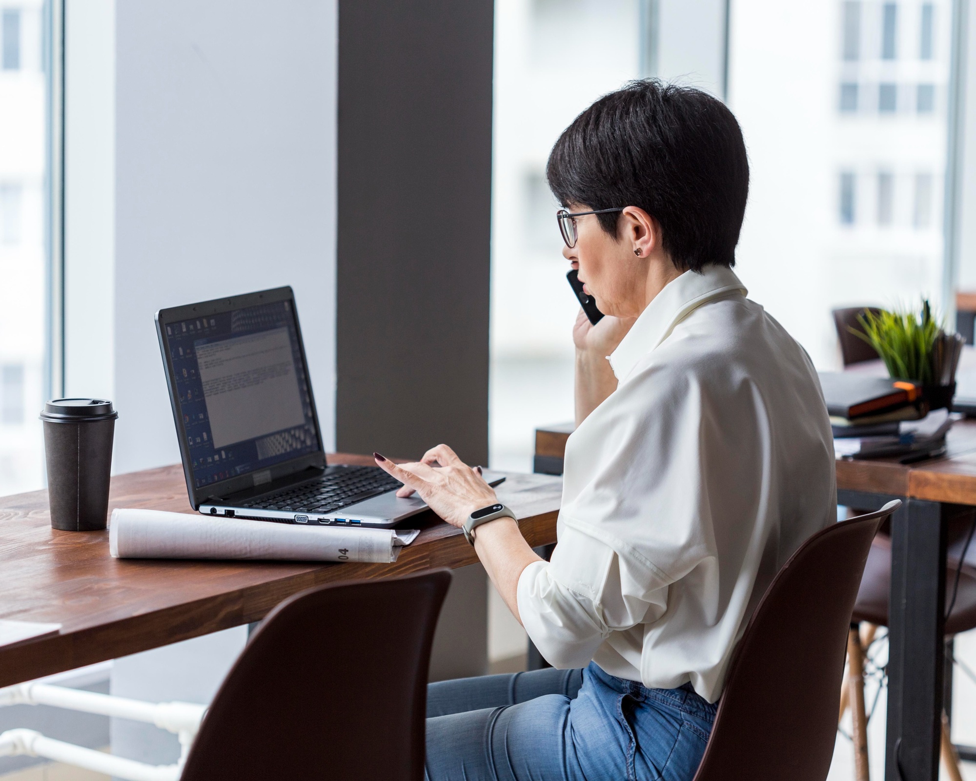 Seorang wanita sedang membaca berita perubahan besaran UMR Jakarta di laptop.