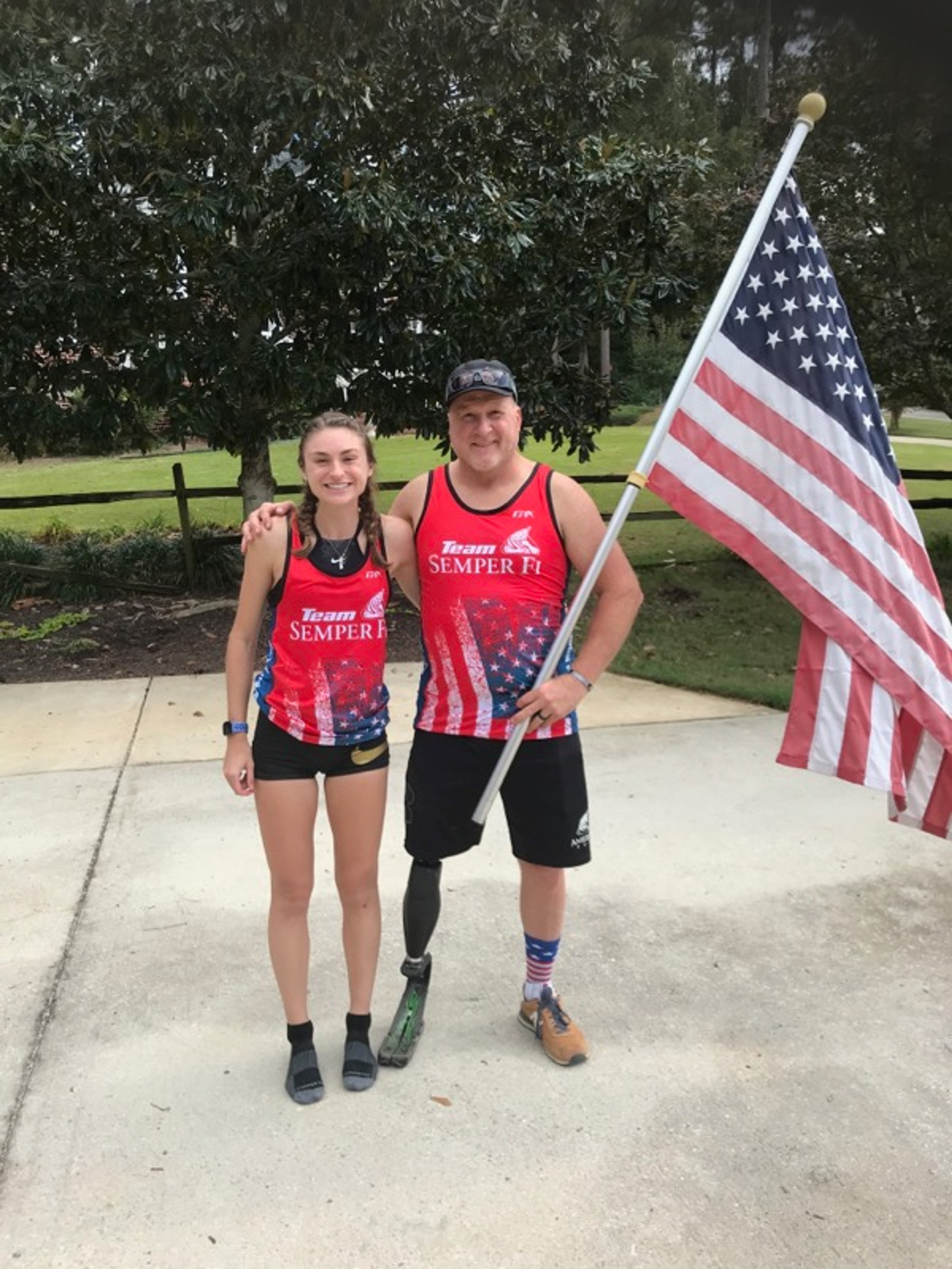 Pete Way posing with his daughter holding the American flag